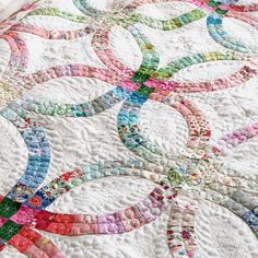 a close up of a quilt on a bed with circles in the middle and one circle at the center