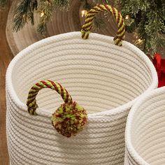 two white baskets sitting next to each other under a christmas tree