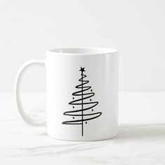 a white coffee mug with a black christmas tree on it