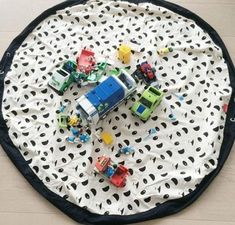 a black and white play mat with toy cars on the floor in front of it