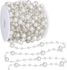 a spool of white pearls on a chain with a roll of the spool