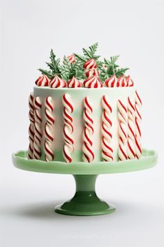 a green cake with white and red candy canes