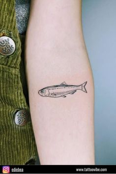 a small fish tattoo on the arm