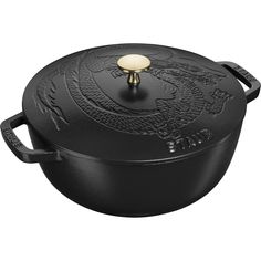 a black cast iron pot with a dragon design on the lid