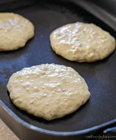 four hamburger patties are being cooked in a pan