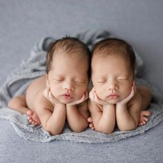 two twin babies are sleeping together on a blanket