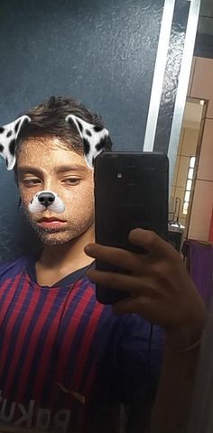 a man taking a selfie with his dog's face painted like a dalmatian