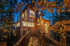 a tree house built into the side of a hill at night with lights on it's windows