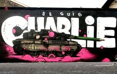 a graffiti wall with a tank painted on it and the words charlie written in large letters