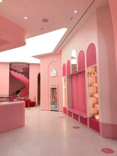 the interior of a store with pink walls and shelves