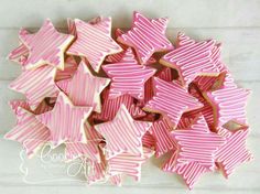 pink and white striped cookies are on the table