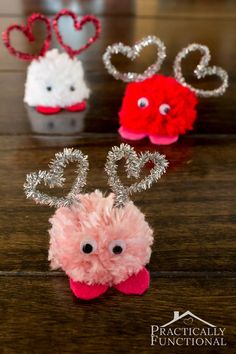 three small stuffed animals sitting on top of a wooden table