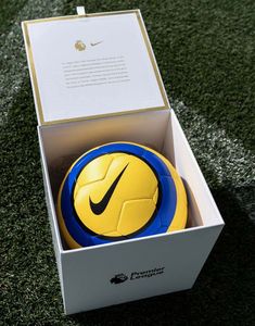 a yellow and blue soccer ball in a box