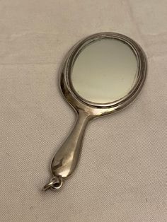 a magnifying glass sitting on top of a white cloth covered table next to a mirror