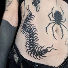 a woman's stomach with a scorpion and spider tattoo on the side, which is black in color