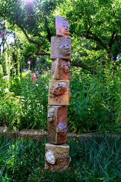 a stone pillar in the middle of a garden