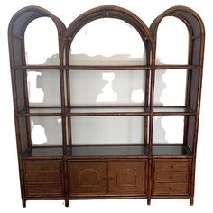 an old wooden bookcase with glass doors and drawers on the bottom shelf is made out of wicker