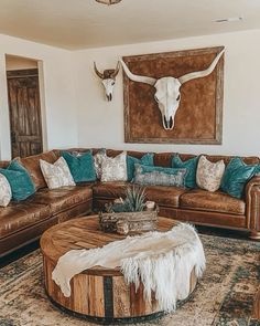 a living room filled with furniture and a cow skull mounted on the wall above it