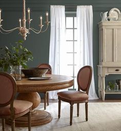 a dining room table and chairs in front of a window