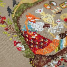 a close up view of a cross - stitch pattern on a piece of cloth with an image of a bird