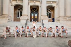 a bride and groom posing with their wedding party in front of a building on the steps