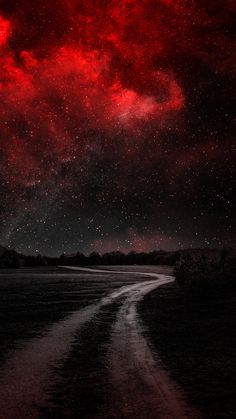 a red sky filled with lots of stars above a dirt road in the middle of nowhere