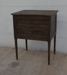 an old wooden table with two drawers on one side and a drawer on the other