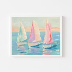 three sailboats floating in the ocean on a sunny day with pink and blue sky