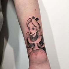 a woman's arm with a black and white drawing of a girl holding a cup