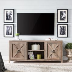 an entertainment center in a living room with pictures on the wall and a flat screen tv