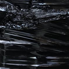 a large pile of black plastic bags sitting on top of a table