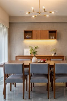 a dining room table with four chairs and a potted plant on the top shelf