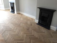 an empty room with a wood floor and fireplace