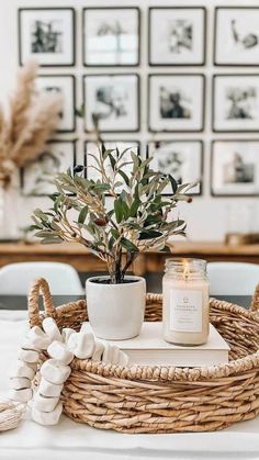 a wicker basket with a candle and potted plant sitting on top of it