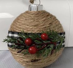 an ornament hanging from a rope with berries on it