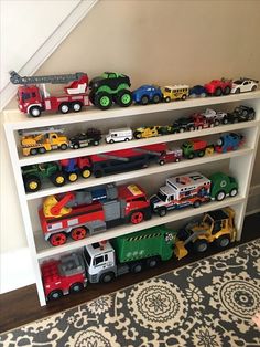 a white bookcase filled with lots of toy trucks on top of it's shelves