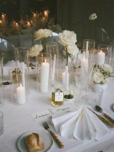 the table is set with white flowers and candles