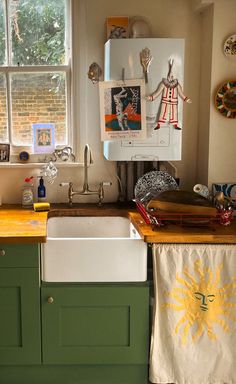 a kitchen with green cabinets and a white sink