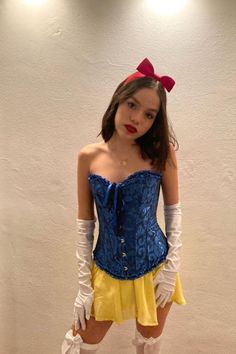 a woman in a blue corset and yellow skirt is posing for the camera