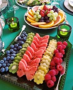 a table topped with plates of fruit and watermelon cut in half to look like animals