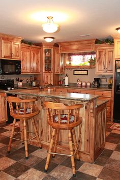 a kitchen with two stools at the island