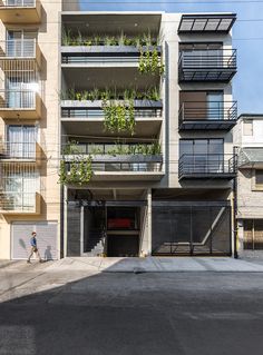 an apartment building with plants growing on the balconies