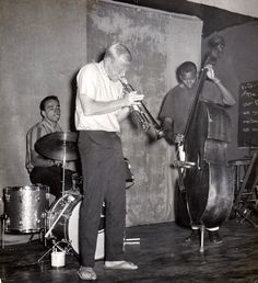 an old black and white photo of three men playing instruments in front of a chalkboard