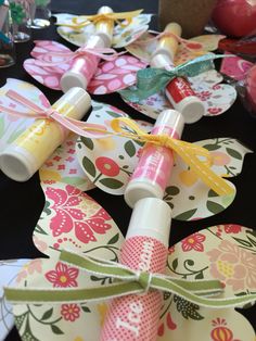 some paper flowers are tied up with twine and ribbons on a black tablecloth