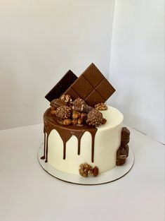 a white cake with chocolate and nuts on top