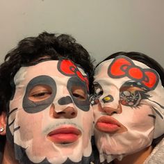 two people with their faces painted like hello kitty masks