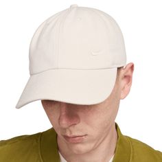 a man wearing a white hat with the nike logo on it's brim