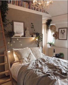 a bed with white sheets and pillows in a bedroom next to a ladder that has lights on it