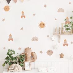 a white table topped with a potted plant next to a wall covered in stars