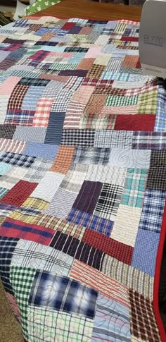 a quilt made from men's shirt scraps cut rectangles